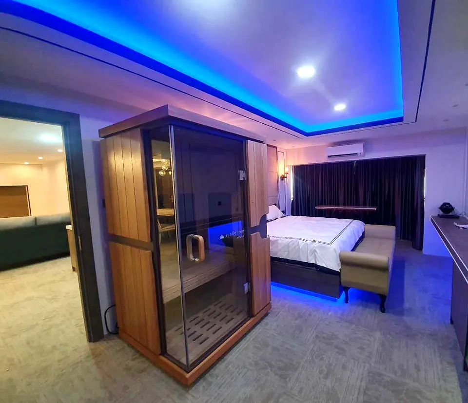 Bedroom with a built-in sauna cabin and LED cove lighting