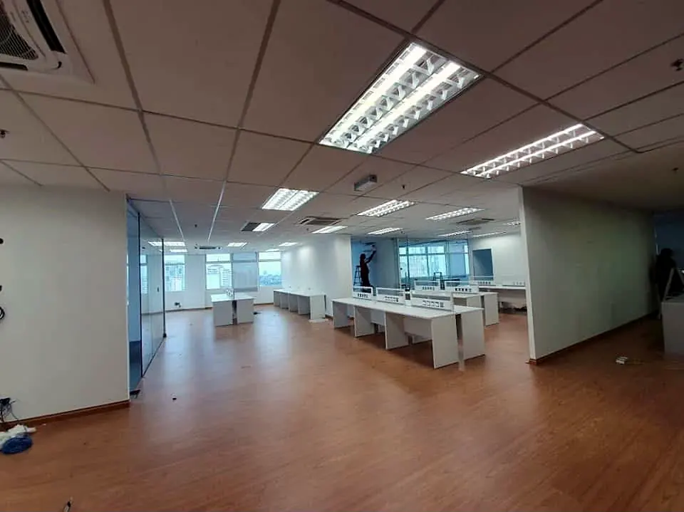 After: the same office with a new ceiling, timber-look floor and workstations