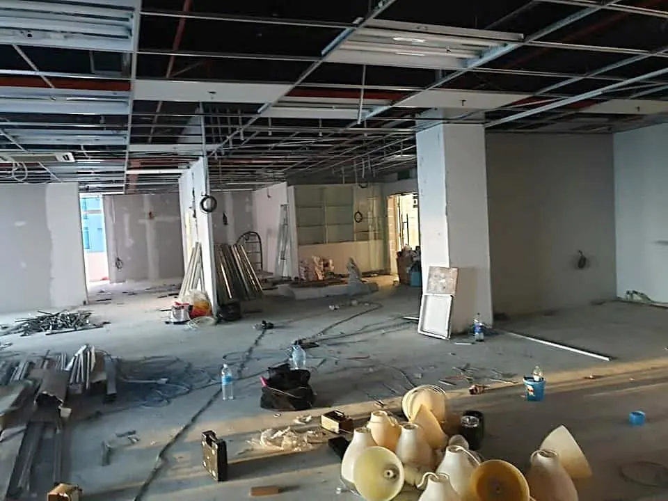 Before: the strip-out, with old fittings piled on the bare floor